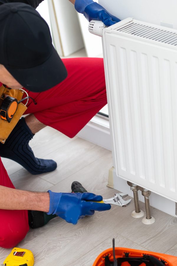 Repair heating radiator close-up. man repairing radiator with wrench. Removing air from the radiator. High quality photo