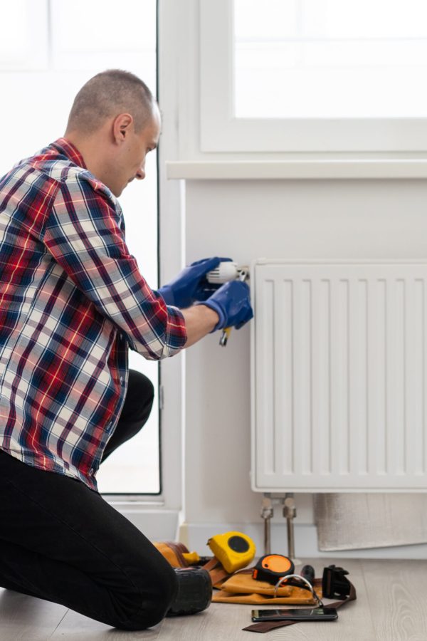 Repair heating radiator close-up. man repairing radiator with wrench. Removing air from the radiator. High quality photo