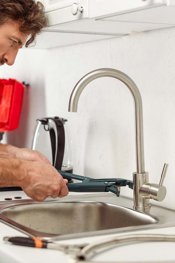 side-view-of-handsome-repairman-using-pipe-wrench-resize.jpg
