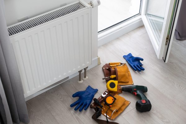 White hot water heater radiator built inside drywall indoors at home. Custom made structure but reduce the efficiency of heating. High quality photo